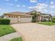 Paver driveway leads to a three-car garage, complimenting the home's well-maintained exterior at 11144 Brambleleaf Way, Hudson, FL 34667