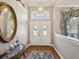 Bright foyer featuring double front doors, wood floors, and an elegant mirror with stylish decor at 11144 Brambleleaf Way, Hudson, FL 34667