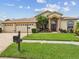 Charming single-story home with a well-manicured lawn, mature landscaping, and a three-car garage at 11144 Brambleleaf Way, Hudson, FL 34667