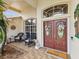Cozy front porch featuring comfortable seating, decorative accents, and a welcoming double-door entry at 11144 Brambleleaf Way, Hudson, FL 34667