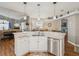 Kitchen with a large island featuring a stainless steel dishwasher, a sink, and light marble countertops at 11144 Brambleleaf Way, Hudson, FL 34667