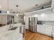Bright kitchen with white cabinets, stainless steel appliances, and a granite countertop island for seating at 11144 Brambleleaf Way, Hudson, FL 34667