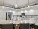 Open concept kitchen featuring white cabinetry, stainless steel appliances, marble countertops, and decorative pendant lighting at 11144 Brambleleaf Way, Hudson, FL 34667