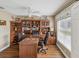 This spacious office features wood floors, a ceiling fan, a large window and custom built-in shelving at 11144 Brambleleaf Way, Hudson, FL 34667