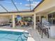 Outdoor oasis with a pool, covered seating, bar area, and outdoor kitchen at 11144 Brambleleaf Way, Hudson, FL 34667