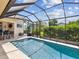 Inviting pool area, featuring a screened-in enclosure and well-maintained landscaping at 11144 Brambleleaf Way, Hudson, FL 34667