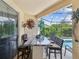Outdoor bar area featuring a stone countertop, bar stool seating, and clear views of the refreshing pool and tropical landscape at 11144 Brambleleaf Way, Hudson, FL 34667