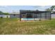 Backyard view of a screened-in pool and surrounding grass at 11280 Sedgefield Ave, Spring Hill, FL 34608