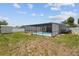 Backyard view of a screened-in pool and grass with a shed at 11280 Sedgefield Ave, Spring Hill, FL 34608