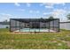 Backyard view of a screened-in pool and surrounding grass at 11280 Sedgefield Ave, Spring Hill, FL 34608