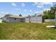 Backyard view showing a screened-in pool area and lawn at 11280 Sedgefield Ave, Spring Hill, FL 34608