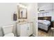 Cozy bathroom with white vanity, wood-framed mirror, and toilet adjacent to the primary bedroom at 11280 Sedgefield Ave, Spring Hill, FL 34608