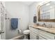 Bathroom with a wood-framed mirror, granite countertops, and a shower with a patterned shower curtain at 11280 Sedgefield Ave, Spring Hill, FL 34608