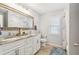 Bathroom featuring double sinks, a wood-framed mirror, and wood-look flooring at 11280 Sedgefield Ave, Spring Hill, FL 34608