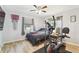 Bedroom with wood-look flooring, ceiling fan, and exercise equipment at 11280 Sedgefield Ave, Spring Hill, FL 34608