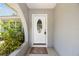 Charming front door with decorative glass and a welcoming mat in a textured archway at 11280 Sedgefield Ave, Spring Hill, FL 34608