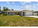 Beautiful one-story home featuring a well-manicured lawn, attached garage, and an arched front entrance at 11280 Sedgefield Ave, Spring Hill, FL 34608