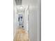 Hallway featuring wood-look floors and neutral paint, leading to various rooms in the home at 11280 Sedgefield Ave, Spring Hill, FL 34608