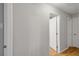 Hallway featuring wood-look floors and neutral paint, leading to various rooms in the home at 11280 Sedgefield Ave, Spring Hill, FL 34608