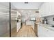 Open kitchen featuring stainless steel appliances, granite countertops, and wood-look floors at 11280 Sedgefield Ave, Spring Hill, FL 34608