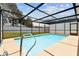 Screened-in pool with bright blue water and a ladder at 11280 Sedgefield Ave, Spring Hill, FL 34608