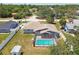 Overhead shot displaying a screened-in pool, manicured lawn, and a storage shed, all within a fenced yard at 11280 Sedgefield Ave, Spring Hill, FL 34608