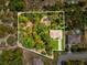 Aerial view of property boundaries showcasing a lush landscape, house, and outlining property lines at 12229 Barnevelde Rd, Weeki Wachee, FL 34614