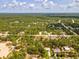 Aerial view of the property highlighted by the red arrow, nestled among lush trees in a serene neighborhood at 12229 Barnevelde Rd, Weeki Wachee, FL 34614