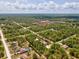 Aerial view of the property highlighted by the red arrow, nestled among lush trees in a serene neighborhood at 12229 Barnevelde Rd, Weeki Wachee, FL 34614
