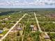Aerial view of the property highlighted by the red arrow, nestled among lush trees in a serene neighborhood at 12229 Barnevelde Rd, Weeki Wachee, FL 34614