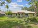 Back exterior view of a home with a metal roof, fenced yard, pergola, and well-maintained lawn at 12229 Barnevelde Rd, Weeki Wachee, FL 34614