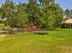 Expansive backyard enclosed by a chain-link fence, surrounded by mature trees and lush greenery at 12229 Barnevelde Rd, Weeki Wachee, FL 34614
