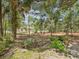 Backyard with flower garden, mature trees, and natural landscaping, providing a private retreat at 12229 Barnevelde Rd, Weeki Wachee, FL 34614