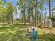 Expansive backyard featuring a well system, greenhouse, shed, and surrounded by mature trees at 12229 Barnevelde Rd, Weeki Wachee, FL 34614