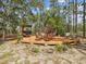 Relaxing outdoor deck featuring outdoor seating, an umbrella, and a charming pergola among the trees at 12229 Barnevelde Rd, Weeki Wachee, FL 34614