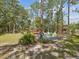 Backyard area with a wooden deck, fire pit surrounded by colorful chairs, and a wooden pergola at 12229 Barnevelde Rd, Weeki Wachee, FL 34614