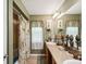 Bathroom featuring dual sinks, a large mirror, and tub-shower combo with decorative palm tree shower curtain at 12229 Barnevelde Rd, Weeki Wachee, FL 34614