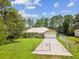 Charming home featuring a metal roof, fenced yard, and well-maintained landscaping, offering curb appeal and security at 12229 Barnevelde Rd, Weeki Wachee, FL 34614