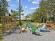 Backyard with fire pit surrounded by colorful chairs, wooden pergola, and a glimpse of the house at 12229 Barnevelde Rd, Weeki Wachee, FL 34614