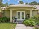 Inviting front porch with decorative double doors, complemented by lush greenery and charming decor at 12229 Barnevelde Rd, Weeki Wachee, FL 34614