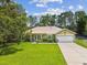 Charming single-story home with a well-manicured lawn and beautiful landscaping, featuring a metal roof at 12229 Barnevelde Rd, Weeki Wachee, FL 34614