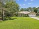 Charming single-story home with a well-manicured lawn and beautiful landscaping, featuring a metal roof at 12229 Barnevelde Rd, Weeki Wachee, FL 34614