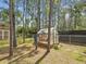 Greenhouse in a backyard, surrounded by tall trees and partially enclosed by a chain-link fence at 12229 Barnevelde Rd, Weeki Wachee, FL 34614