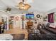 Comfortable living room with a fireplace, wood floors, and a large ceiling fan, perfect for relaxing and entertaining at 12229 Barnevelde Rd, Weeki Wachee, FL 34614
