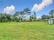 Large, well-maintained backyard with lush green grass, mature trees, and a serene setting at 12323 House Finch, Weeki Wachee, FL 34614