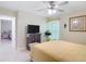 Bright bedroom with a TV, light yellow walls, and a view to an adjacent room at 12323 House Finch, Weeki Wachee, FL 34614