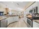 Bright, airy kitchen boasts white cabinets, granite countertops, and stainless steel appliances at 1242 Almondwood Dr, Trinity, FL 34655