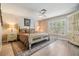 Serene main bedroom features a four-poster bed, wood floors, and a bright window with shutters at 1242 Almondwood Dr, Trinity, FL 34655