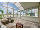 Serene sunroom with views of the lake, features comfortable seating, and plenty of natural light at 1242 Almondwood Dr, Trinity, FL 34655