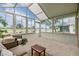 Bright sunroom with expansive windows offering serene views of the golf course and water at 1242 Almondwood Dr, Trinity, FL 34655